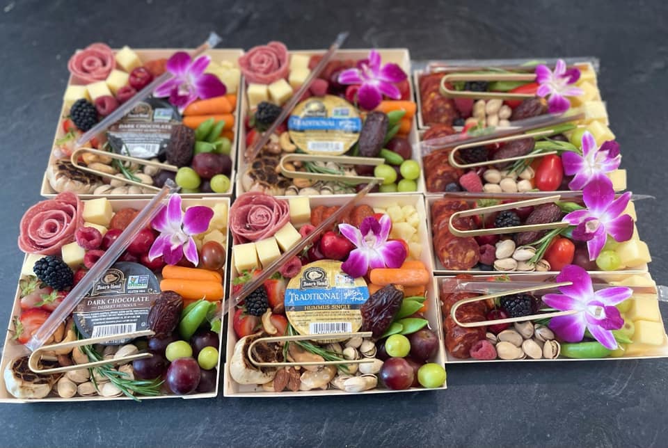 Small charcuterie catered boxes with beautiful pink flower